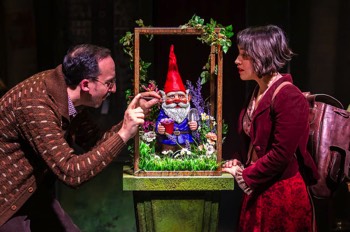 Amelie The Musical Production Image. Raphael Pulin (Jez Unwin) touches up the paint on his garden gnome on a very elaborate plinth adorned with vines. Amelie (Audrey Brisson) stands beside watching.