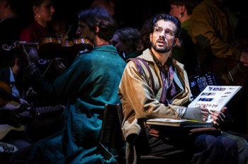  Amelie The Musical Production Image. Nino (Danny Mac) is sat on a bench looking at his photo album. 