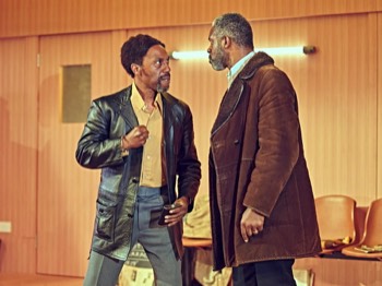 Jitney Production Image. Fielding (Tony Marshall) raises a fist at Becker (Wil Johnson) who leans into him.