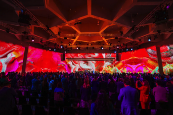 A wide angle shot of the congress hall stage and ceiling, with full width video projections created by Refik Anadol.